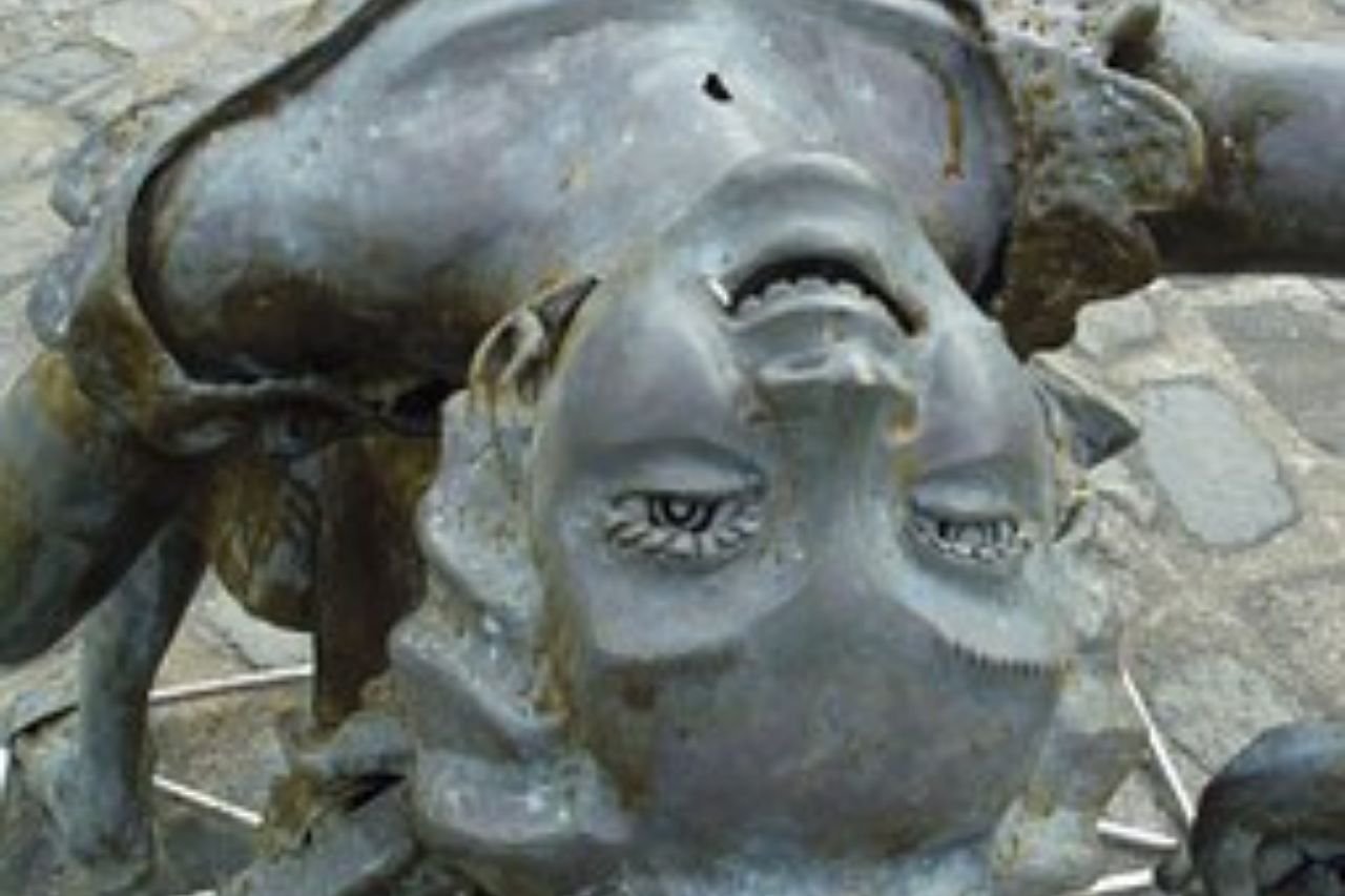Statue of a smiley girl leaning upside down